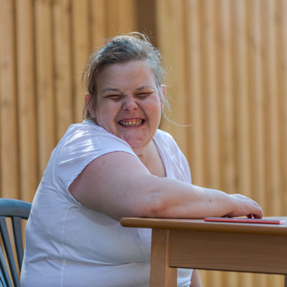 300-Woman-sat-at-bench-grin